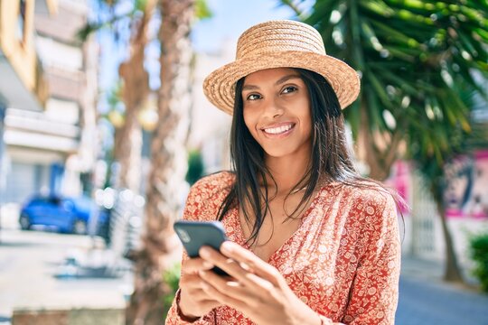 Young african american tourist woman on vacation smiling happy using smartphone at the city.