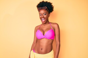 Young african american woman wearing bikini winking looking at the camera with sexy expression,...
