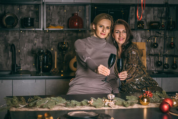 Two pretty women are celebrating the Christmas holiday on the festive home background