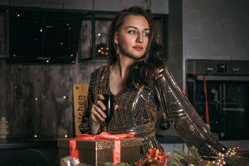 Young pretty woman close up with black glass of champagne on the festive decorations background.Christmas photo