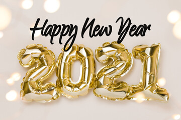 Happy New Year celebration. Gold foil balloons numeral 2021, party decoration and confetti stars on beige background.