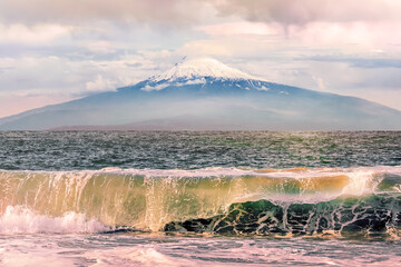 Waves of Lake Sevan with foam and splashes against the background of Mount Ararat