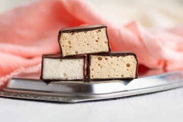 Chocolate souffle sweets or bird's milk on a white wooden table. Selective focus