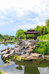 Fototapeta na wymiar Beautiful japanese gazebo by a pond in Japanese garden