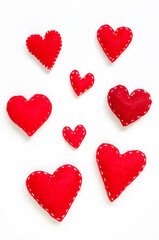 Red felt hearts set. Handmade love symbol with white stitches on white. 