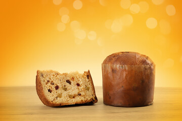Delicious slice of Panettone with candied fruit on the table on a blurred background.