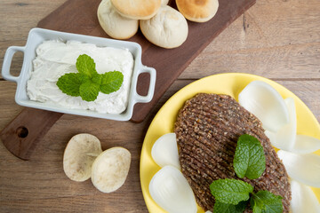 raw quibe with sliced onion, dried curd, pita bread and mint leaves