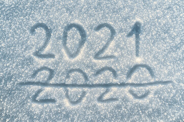Finger lettering on snow 2021. Snow texture. Inscription 2021 written on snowy surface, symbol of the next year. New year concept