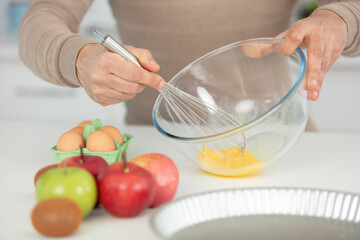 closeup on mans hands whisking eggs in bowl