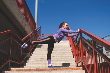 young woman doing pushups  on the stairs on the street, urban sports concept