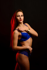 Beautiful sexy woman in blue underwear on dark background, perfect female body, studio shot