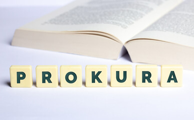 Prokura in Buchstaben mit Buch im Hintergrund