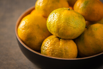 Tangerines or mandarines in bamboo bowl close up selective focus
