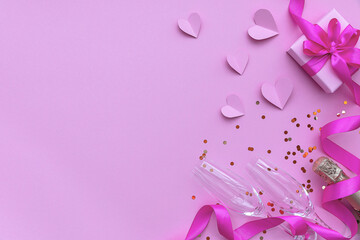 Champagne and two glasses with a gift box with a ribbon on a pink background with hearts. The concept of Valentine's Day. Flat lay, top view, copy space.