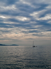 Fototapeta premium A lone sailboat comes back from the sea to the land