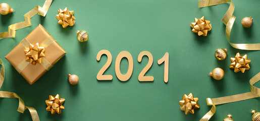 Fototapeta na wymiar Christmas banner with golden gift and balls on green background. Top view. New 2021 Year greeting card.