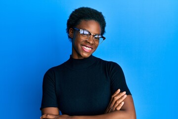 Young african american girl wearing casual clothes and glasses happy face smiling with crossed arms...