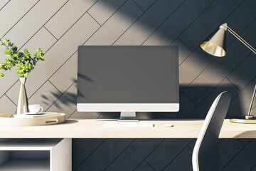 Designer desktop with blank white computer screen