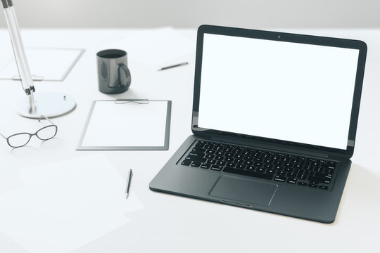 Modern office desktop with empty laptop screen