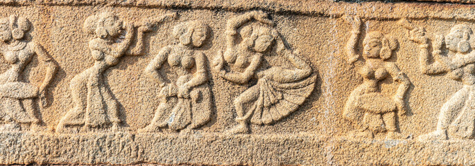 Hampi, Karnataka, India - November 4, 2013: Mural sculpture on stone at Royal Enclosure. base of Mahanavami Dibba or the Dussehra Platform. Images of merry and dancing women.