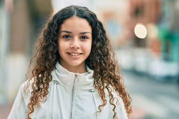 Hispanic teenager girl smiling happy standing at the city.