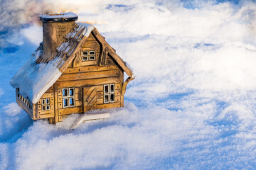 Ceramic model of a house in snow. Holiday concept for Christmas, New Year, and sweet home with copy space