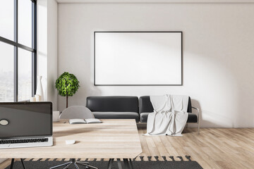 Clean home workplace interior with laptop on table, sofa and blank poster on wall.