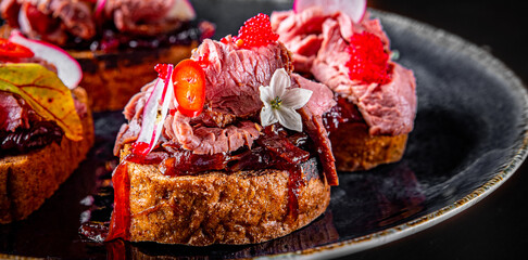 Appetizing bruschetta with roast beef on plate