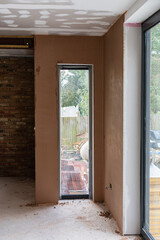 Brown plastered walls in the property, preparation for the paint, unfinished ceiling, selective focus