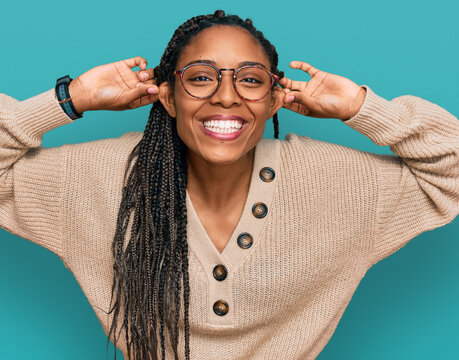 African american woman wearing casual clothes smiling pulling ears with fingers, funny gesture. audition problem