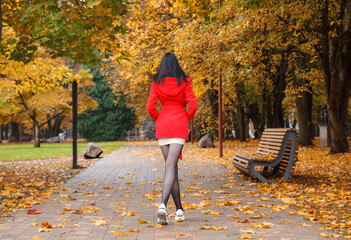 young girl in a red coat walking on the alley