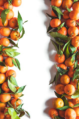 Oranges fruits composition with green leaves and slice on white wooden background, top view