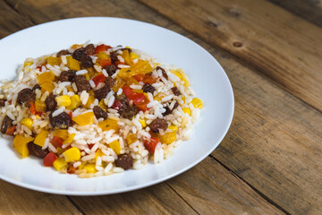 rice with yellow and red pepper and dried grapes and corn, eat healthy