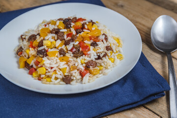 rice with yellow and red pepper and dried grapes and corn, eat healthy