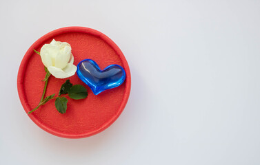 Gift round red box with a heart and a white rose. The concept of Valentine's Day, anniversaries, mother's Day and congratulations on the birthday. Space for text.