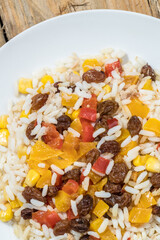 rice with yellow and red pepper and dried grapes and corn, eat healthy