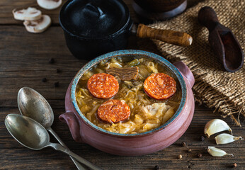 Christmas cabbage soup in ceramic bowl on natural wooden background.