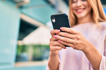 Young caucasian girl smiling happy using smartphone at the city.