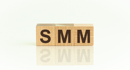 SMM - Social Media Marketing - word is made of wooden building blocks lying on the white table