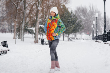 A young athletic girl poses on a frosty and snowy day. Fitness, running