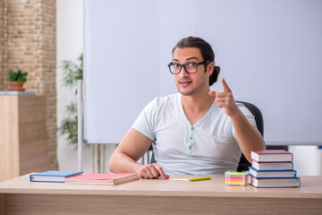 Young male teacher student sitting in the classroom