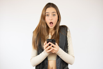 Fototapeta premium Image of joyful caucasian woman holding cellphone in shock isolated over white background