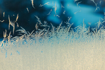beautiful frost pattern on frozen window at dusk, frosty window in evening, frost on window with...