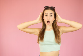 Shocked excited Beautiful caucasian woman with mouth open isolated on colorful pink background