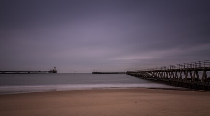 Fototapeta premium Morning at Blyth beach in Northumberland, England, with the old wooden Pier stretching out to the North Sea