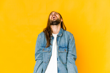 Young man with long hair look relaxed and happy laughing, neck stretched showing teeth.