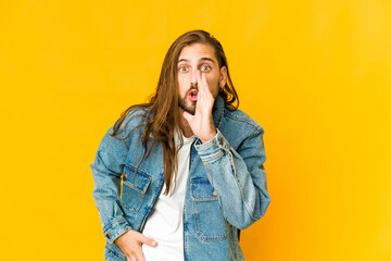 Young man with long hair look is saying a secret hot braking news and looking aside