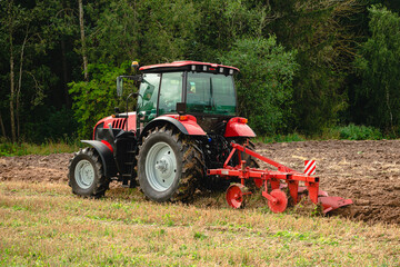Farmer in tractor preparing land for sowing, plowing the field