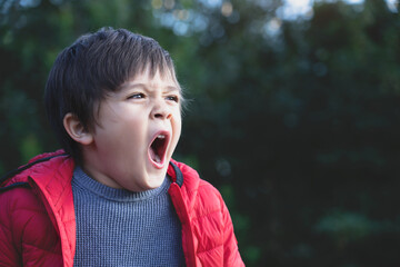 Cropped shot tired child yawning and get a cold during weather change, Child having allergy while playing in the park,kid has reflection or hay fever from dust mite, Allergies in kids