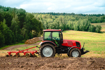 Fototapeta premium Farmer in tractor preparing land for sowing, plowing the field